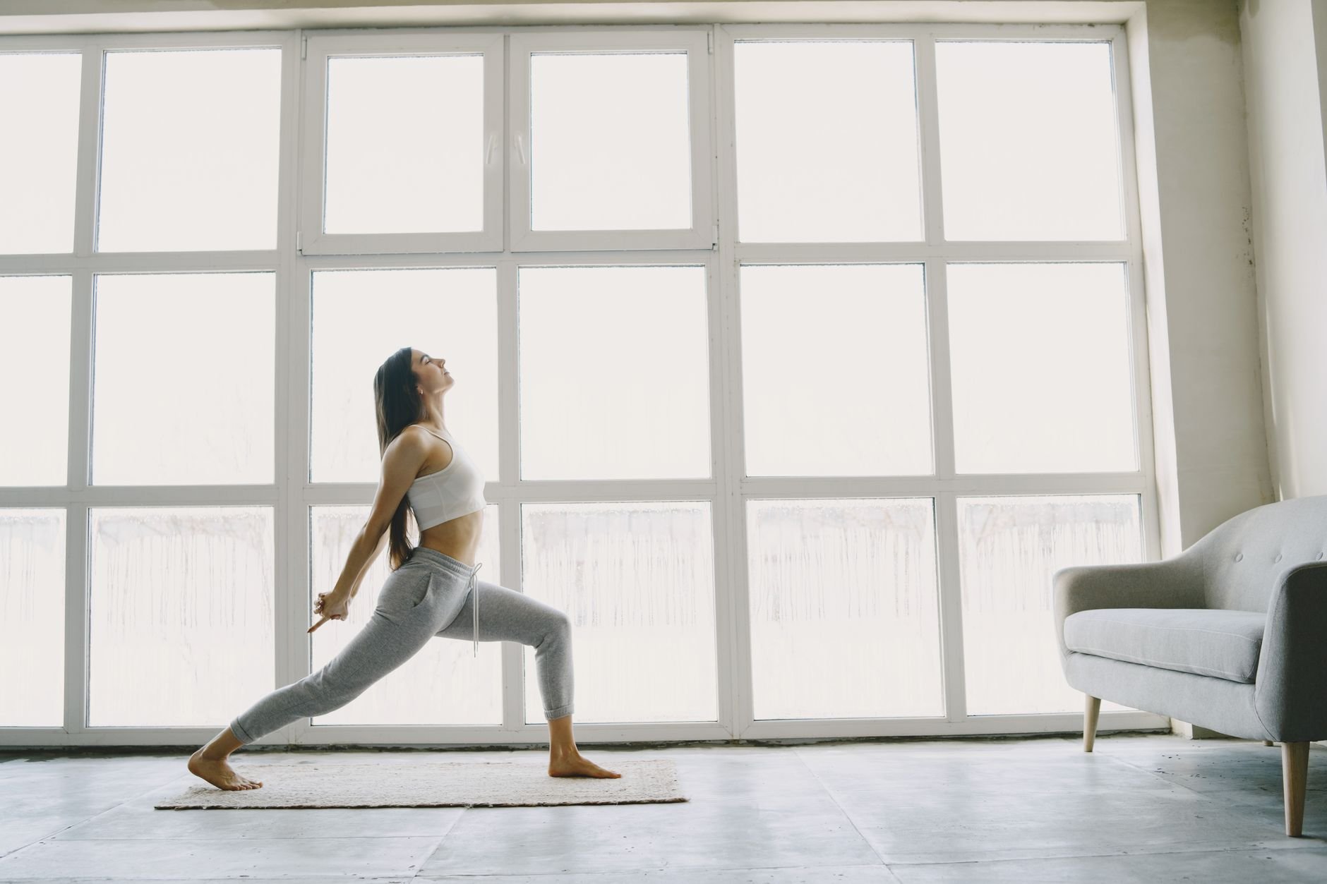 Woman in a serene yoga pose with soft natural light